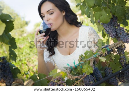 Pretty Mixed Race Young Adult Woman Enjoying A Glass Of Wine In The Vineyard.