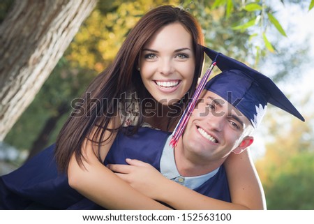 Happy Male Graduate in Cap and Gown and Pretty Girl Celebrate Outside.