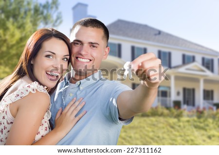Mixed Race Excited Military Couple In Front of New Home Showing Off Their House Keys.