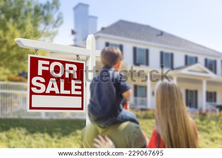 Curious Family Facing For Sale Real Estate Sign and Beautiful New House.