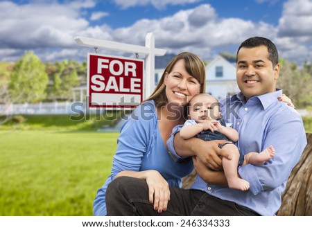 Happy Young Mixed Race Family in Front of For Sale Real Estate Sign and New House.