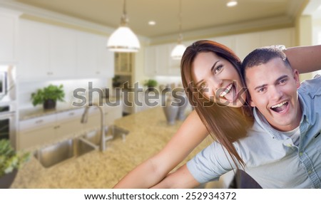 Playful Young Military Couple Inside Home with Beautiful Custom Kitchen.