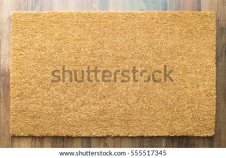 Blank Welcome Mat On Wood Floor Background Ready For Your Own Text.