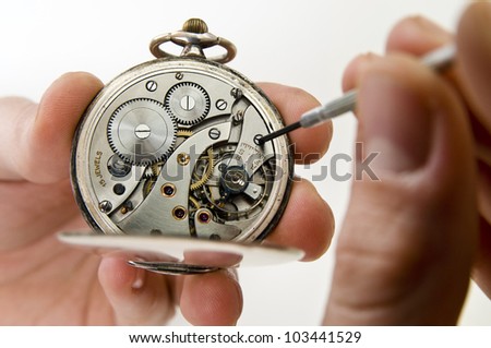 Watchmaker holding antique pocket watch show the clockwork mechanism and repair with screwdriver.