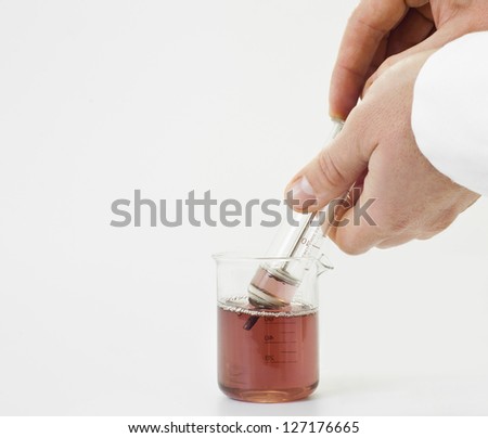Scientist holding old syringe and pump up red chemical.