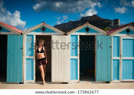 classic beach cabins with a beautiful girl in swimming dress.