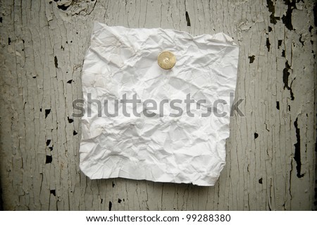 Grungy torn note paper nailed on rustic old weathered background.