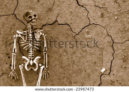 Spooky skeleton on dries and cracked earth