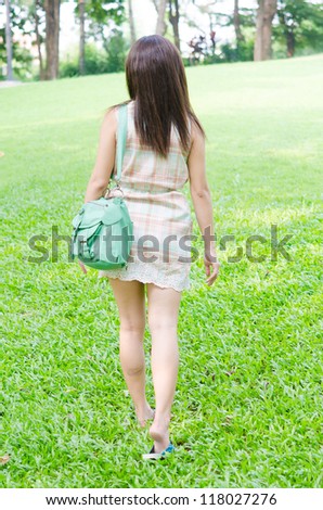 girl walking away in park