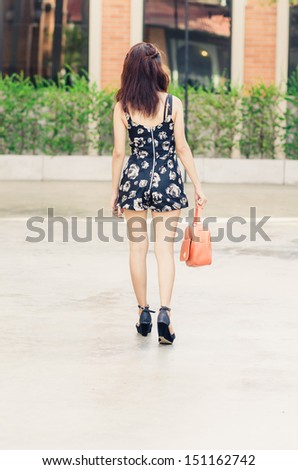 Asian girl walking away in park