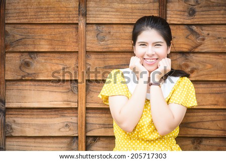 Happy Beautiful Woman Smiling wearing yellow shirt, Asian Woman,Thai woman ,wood background