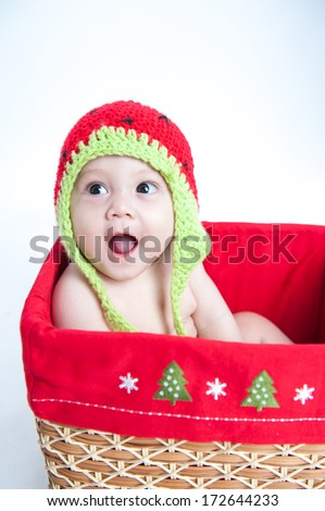 Beauty baby boy wearing crochet hat sitting in a basket