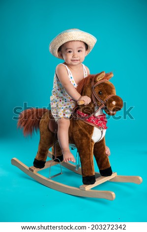little boy on a toy horse.child on a blue background.game