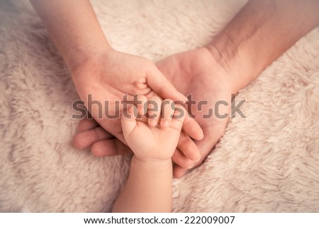 Baby hand. Closeup of baby hand into parents hands. Family concept