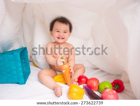 looking at fruit cute smiling baby on white background among fruits. Photo with depth of field