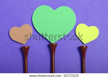 Colorful hearts set on golf tees with color background