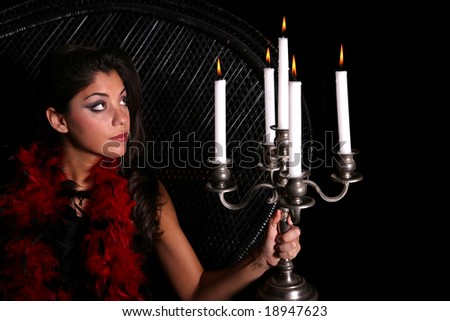 Attractive woman sitting in wicker chair viewing candles