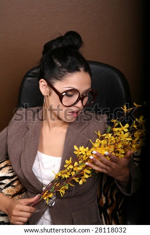 Female in office setting holding yellow flowers
