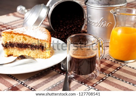 breakfast on the table with coffee, chocolate cake, orange juice and sugar