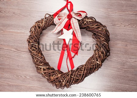 Closeup of heart-shaped christmas or St. Valentine wicker wreath with red felt. Square crop isolated on white