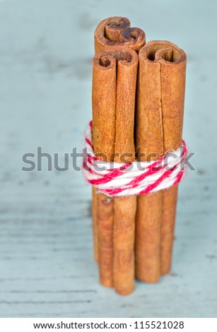 Bunch of cinnamon sticks on light blue wooden shabby chic background