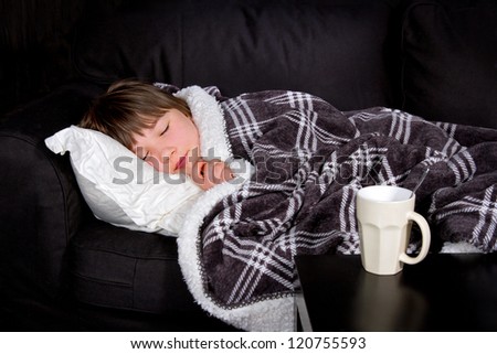 Young girl / child with a flu sleeping on a black couch
