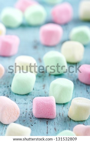 Colorful small marshmallows on light blue wooden background
