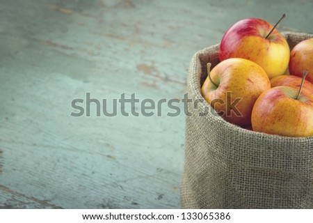 Red apples in a burlap sack with vintage editing and copy space