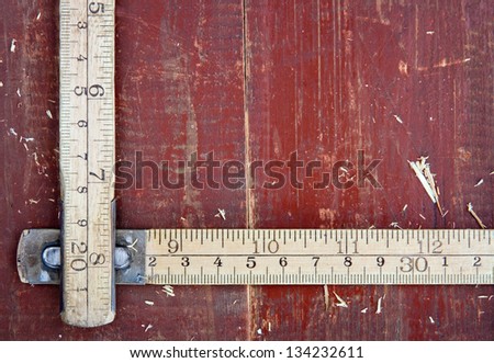 Old wooden meter stick on vintage red wooden background - DIY concept