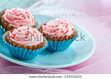 Plate full of yummy pink chocolate confectionary on shabby chic pastel color background