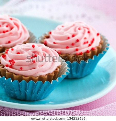 Closeup of delicious pink chocolate bonbons on shabby chic pastel color background