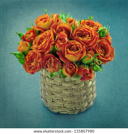 Bouquet of orange roses in a vase on blue vintage shabby chic background