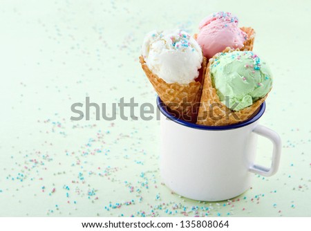 Ice cream cones in an old mug on green background with sprinkles