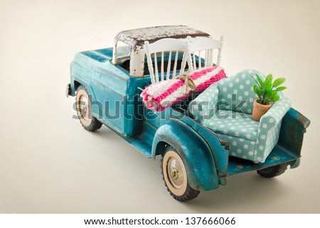 Old vintage toy truck packed with furniture - moving houses concept