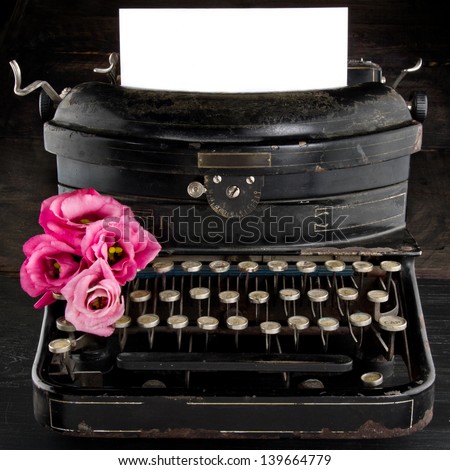 Old antique black vintage typewriter and empty paper for copy space, with red romantic flowers