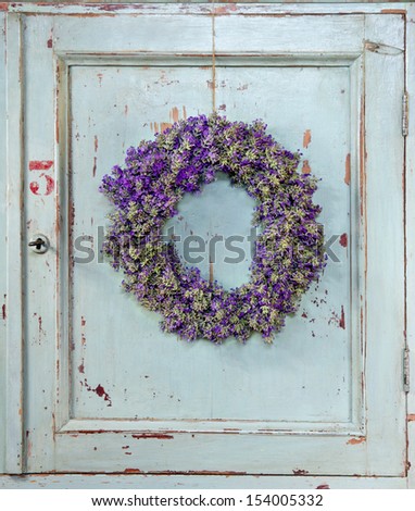 Lavender flower wreath hanging on an old wooden vintage kitchen door frame with copy space
