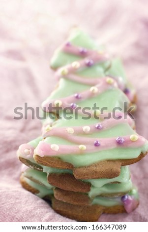 Christmas tree gingerbread cookies with pink frosting on shabby chic pastel background