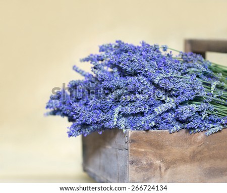 Bouquet of lavender flowers in a vintage wooden basket on terracotta floor