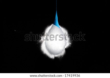 Balloon with water frozen in the moment when the bullet is flying out of it