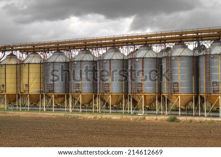 A row of grain silos surrounded by fields