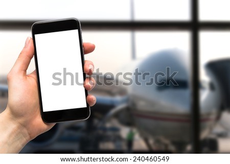 phone in the hand with a blank screen and a plane in the background