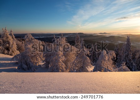 Winter landscape in mountains in the morning. The sun's rays and flare.