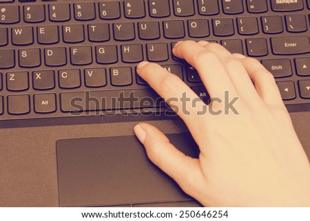 Retro vintage or instagram style image of a businesswoman typing on computer keyboard.