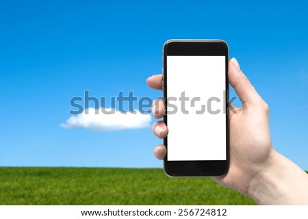 Phone in the hand with a blank screen and a sky background with a meadow
