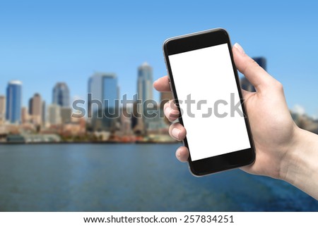 phone in hand and blurred city in the background