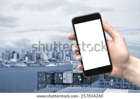 phone in hand and blurred city in the background