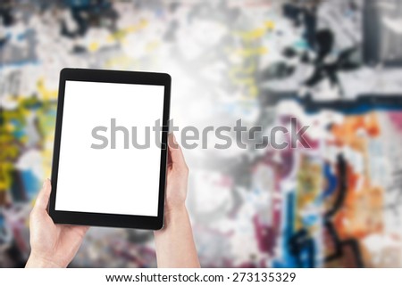 tablet in the hands of women and graffiti in the background