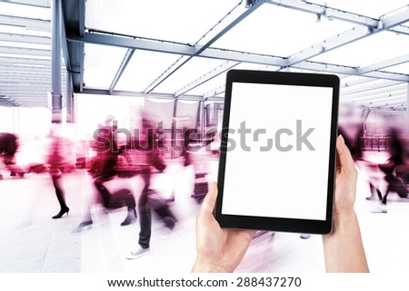 tablet in the hands and the crowd of people in the background