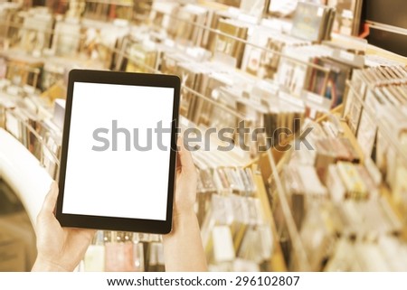 hands hold the tablet and deep rack with plates on music store