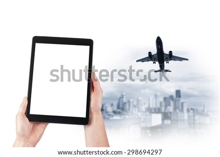 tablet in the hands and the plane over the city